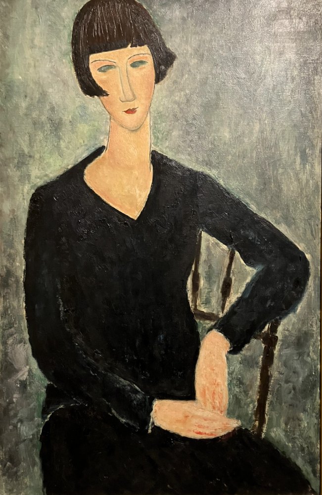 Donna Seduta in Abito Blu